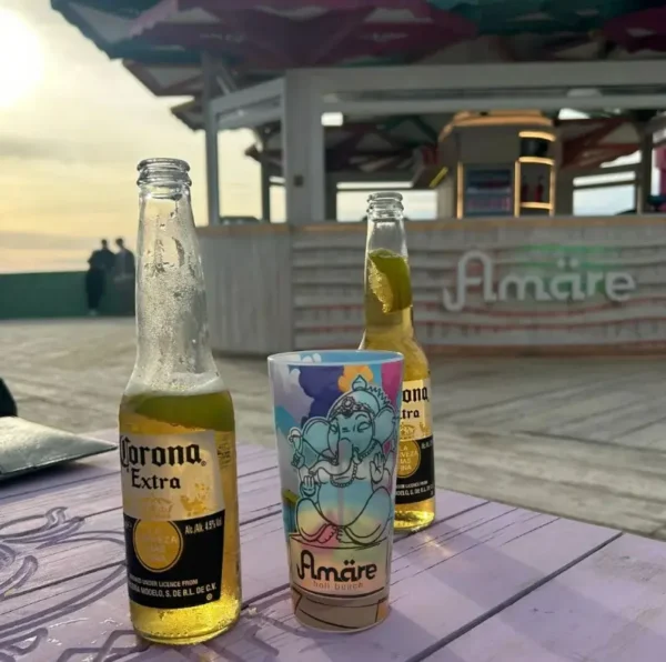 Bicchiere con stampa IML Amare sul tavolo di un bar in spiaggia