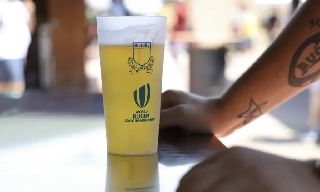 Bicchiere riutilizzabile personalizzato con i loghi FIR e World Rugby U20 Championship, pieno di birra al bar dell’evento